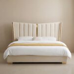 Luxury white upholstered platform bed with a tall wingback channel-tufted headboard, gold metal accents, and a contemporary minimalist design.
