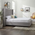 Modern grey upholstered platform bed with a tall wingback vertical channel-tufted headboard and solid wood legs in a contemporary bedroom.