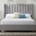 Modern grey upholstered platform bed with a tall wingback vertical channel-tufted headboard and solid wood legs in a contemporary bedroom.