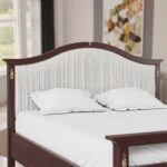Classic walnut solid wood upholstered platform bed with an elegant arched fabric headboard and decorative brass accents in a sophisticated bedroom.