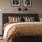 Modern black wooden platform bed with a panel headboard and built-in pull-out storage drawers in a contemporary bedroom.