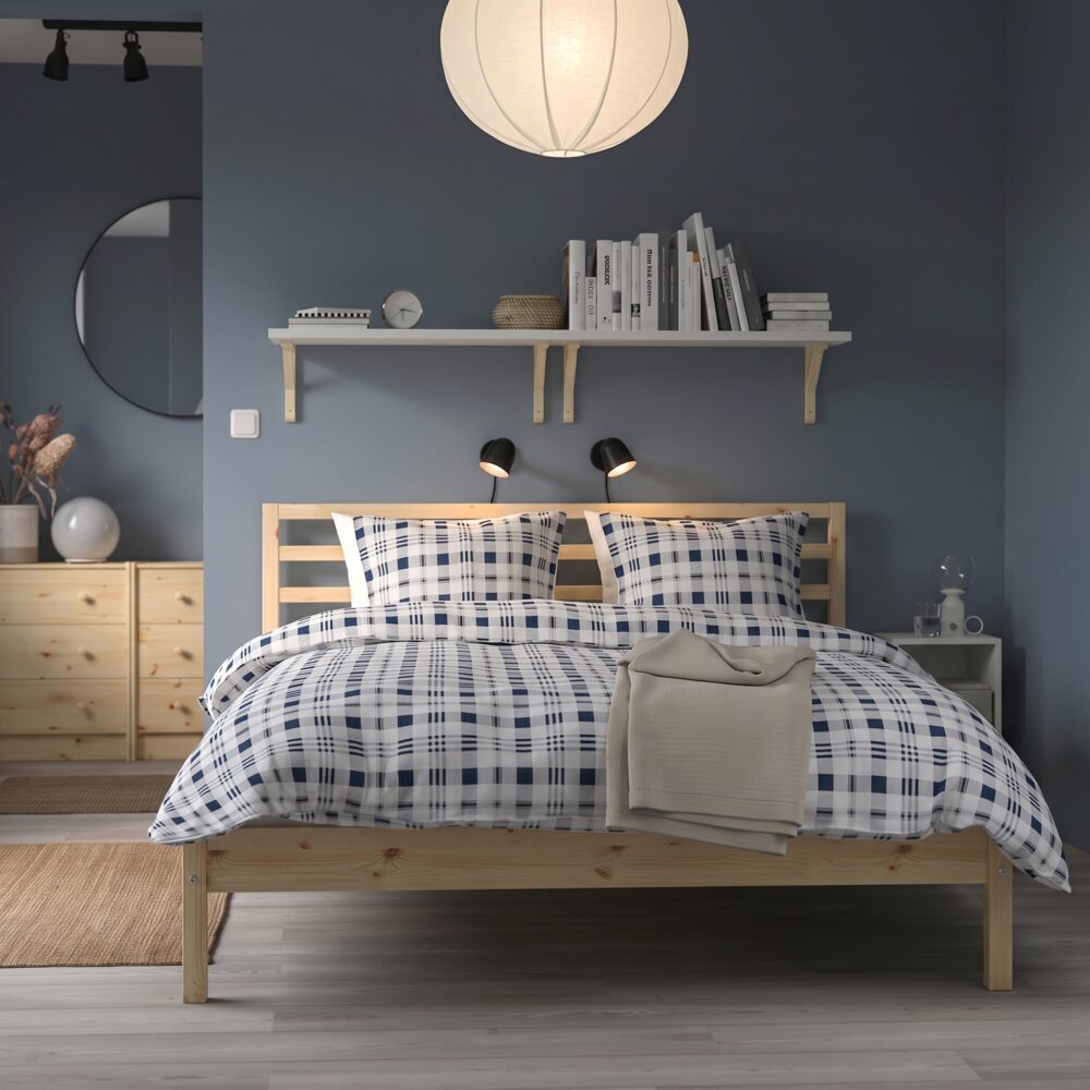 Modern natural wood platform bed with open slatted headboard in a contemporary Scandinavian bedroom featuring minimalist styling and durable wooden frame.