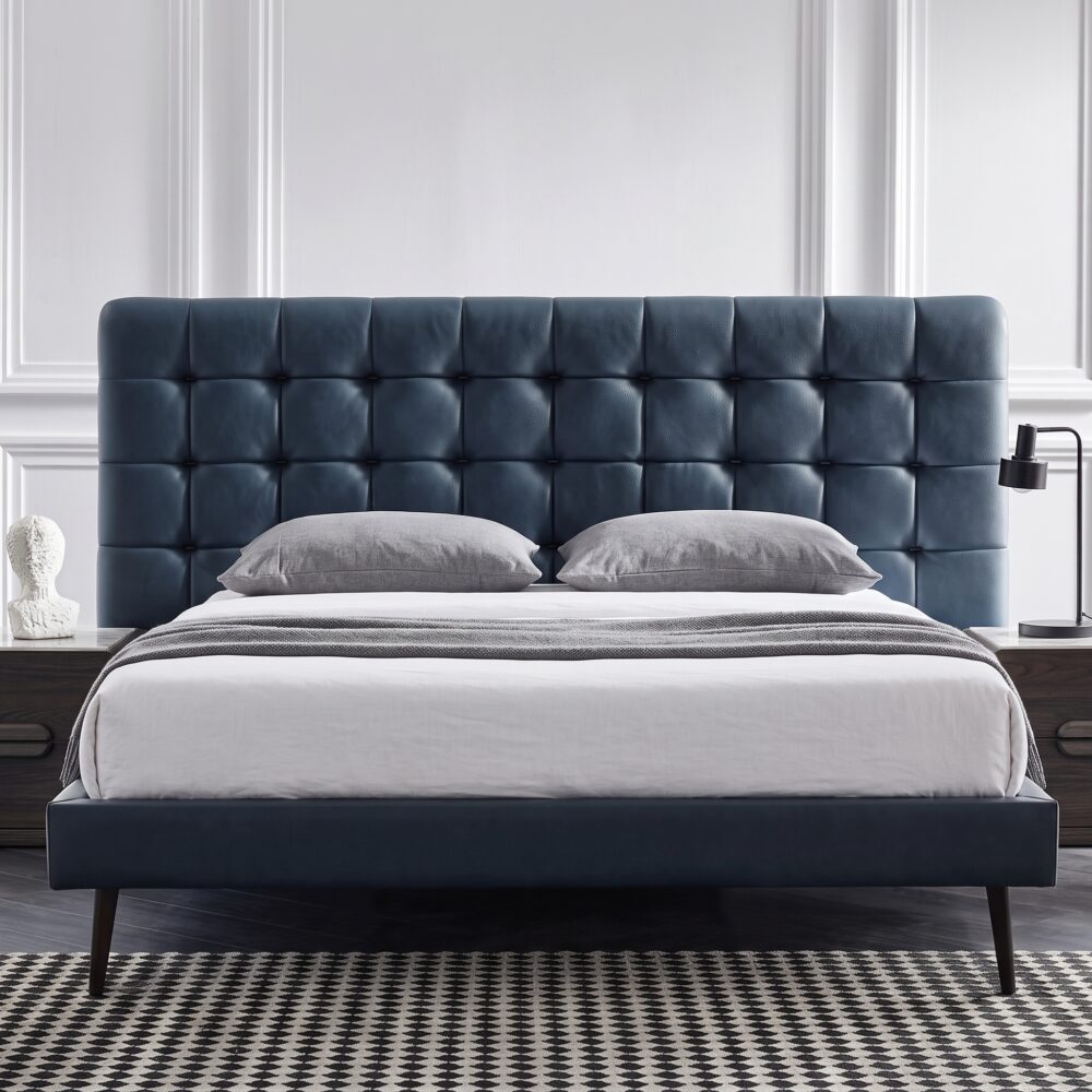 Modern blue upholstered platform bed with button-tufted headboard, wooden legs, and low-profile contemporary frame for stylish bedroom décor.