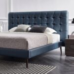 Modern blue upholstered platform bed with button-tufted headboard, wooden legs, and low-profile contemporary frame for stylish bedroom décor.