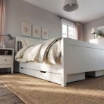 Modern white platform bed with clean panel headboard and pull-out storage drawer in a contemporary bedroom setting.