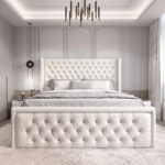 Luxury white upholstered platform bed with diamond-tufted wingback headboard and matching padded footboard in a modern bedroom.