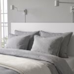 Modern white platform storage bed with built-in drawers, minimalist headboard, contemporary bedroom furniture in matte white finish.