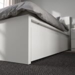Modern white platform storage bed with built-in drawers, minimalist headboard, contemporary bedroom furniture in matte white finish.