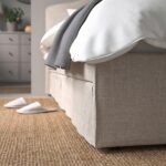 Modern beige upholstered platform bed with curved fabric headboard, contemporary minimalist bedroom furniture, neutral fabric finish, and elegant modern design.