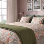 Modern white wooden platform bed with minimalist panel headboard, contemporary bedroom furniture, floral bedding, and clean Scandinavian-inspired design.