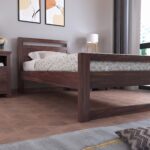 Modern walnut wooden platform bed with minimalist open headboard and sturdy frame in a contemporary bedroom.