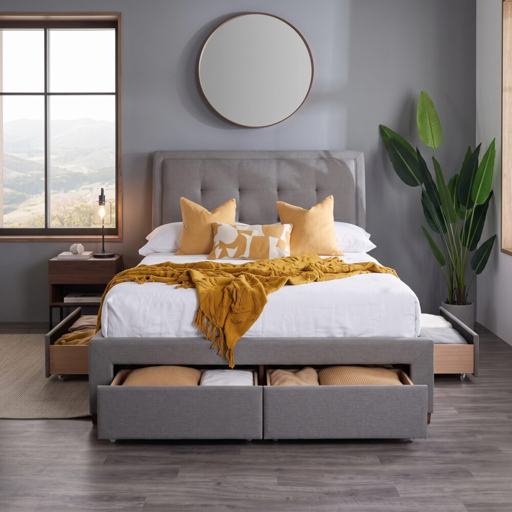 Modern gray upholstered platform bed with padded headboard and four pull-out storage drawers in a contemporary bedroom.