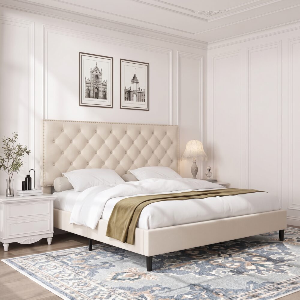 Modern beige upholstered platform bed with button tufted nailhead headboard, low-profile frame, sturdy wooden slats, and elegant contemporary bedroom design.