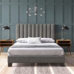 Modern grey upholstered platform bed with a vertical channel tufted headboard, contemporary fabric bed frame, and minimalist bedroom furniture.