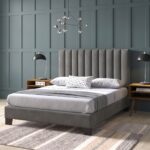 Modern grey upholstered platform bed with a vertical channel tufted headboard, contemporary fabric bed frame, and minimalist bedroom furniture.
