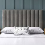 Modern grey upholstered platform bed with a vertical channel tufted headboard, contemporary fabric bed frame, and minimalist bedroom furniture.