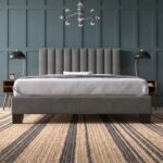 Modern grey upholstered platform bed with a vertical channel tufted headboard, contemporary fabric bed frame, and minimalist bedroom furniture.