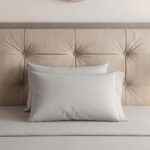 Modern beige upholstered platform bed frame with button-tufted headboard, walnut wood legs, and contemporary minimalist bedroom décor.