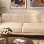 Modern Cream Fluted 3-Seater Sofa with vertical channel tufting, premium cream fabric upholstery, curved armrests, and solid wood base in a contemporary living room.