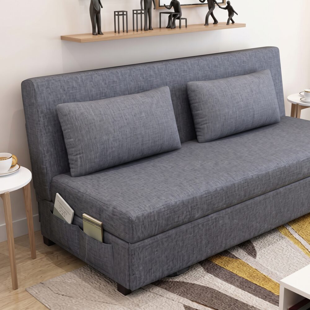 Modern grey fabric sofa cum bed with removable cushions, integrated side storage pockets, and convertible sleeper design in a contemporary living room.