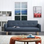 Modern navy blue fabric sofa cum bed with button-tufted backrest, wooden legs, and fold-flat convertible design in a contemporary living room.