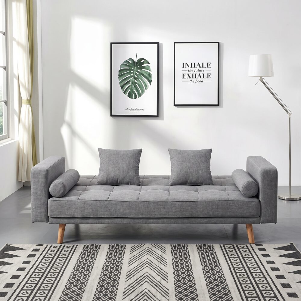 Modern grey fabric convertible sofa bed with tufted backrest, wooden legs, square cushions, bolster pillows, and Scandinavian design for living room furniture.