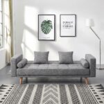 Modern grey fabric convertible sofa bed with tufted backrest, wooden legs, square cushions, bolster pillows, and Scandinavian design for living room furniture.
