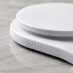 Homslux white digital kitchen scale on a marble countertop next to a bowl of flour