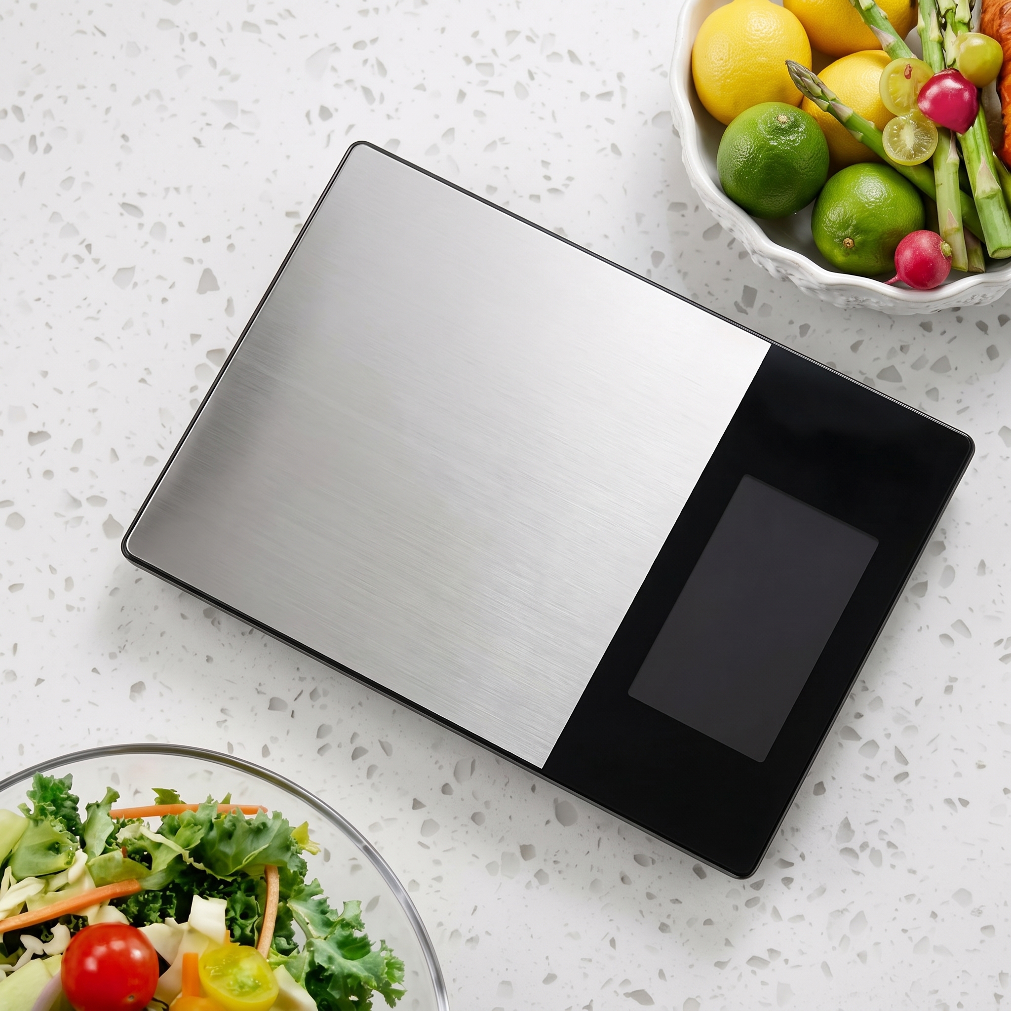 Homslux-stainless-steel-digital-kitchen-scale-large-display.jpg Homslux stainless steel digital kitchen scale with a large black display screen on a white speckled countertop next to fresh vegetables