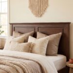 Dark walnut brown single bed with a classic paneled wooden headboard and footboard, styled with cream bedding and a textured beige throw in a cozy bedroom.