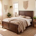 Dark walnut brown single bed with a classic paneled wooden headboard and footboard, styled with cream bedding and a textured beige throw in a cozy bedroom.