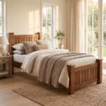 Solid wood single bed frame with mission vertical slats on headboard and footboard styled in a bright bedroom next to a nightstand.