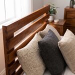 Rustic solid acacia wood single bed frame with horizontal slatted headboard styled with neutral beige waffle bedding in a sunlit bedroom.